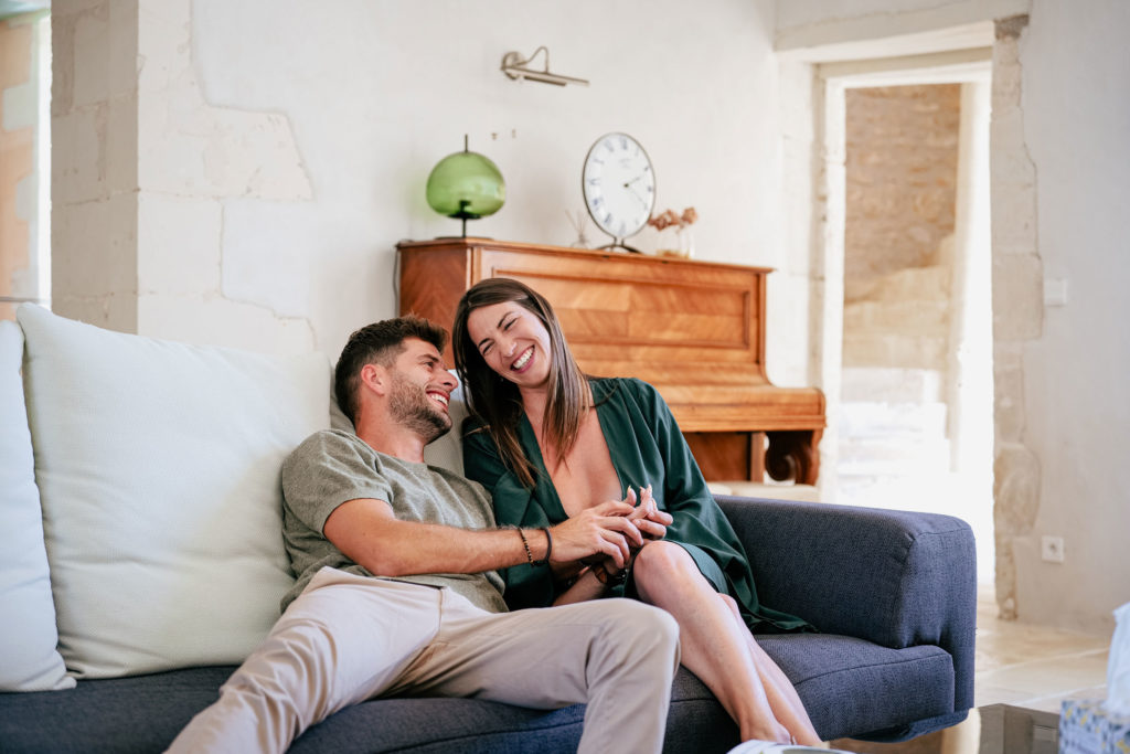 Couple dans un château en train de sourire sur le canapé