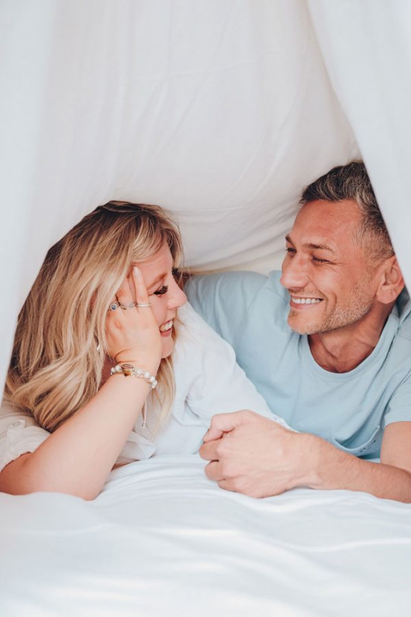 shooting-photo-ete-hotel-couple-sous-les-draps-sourire