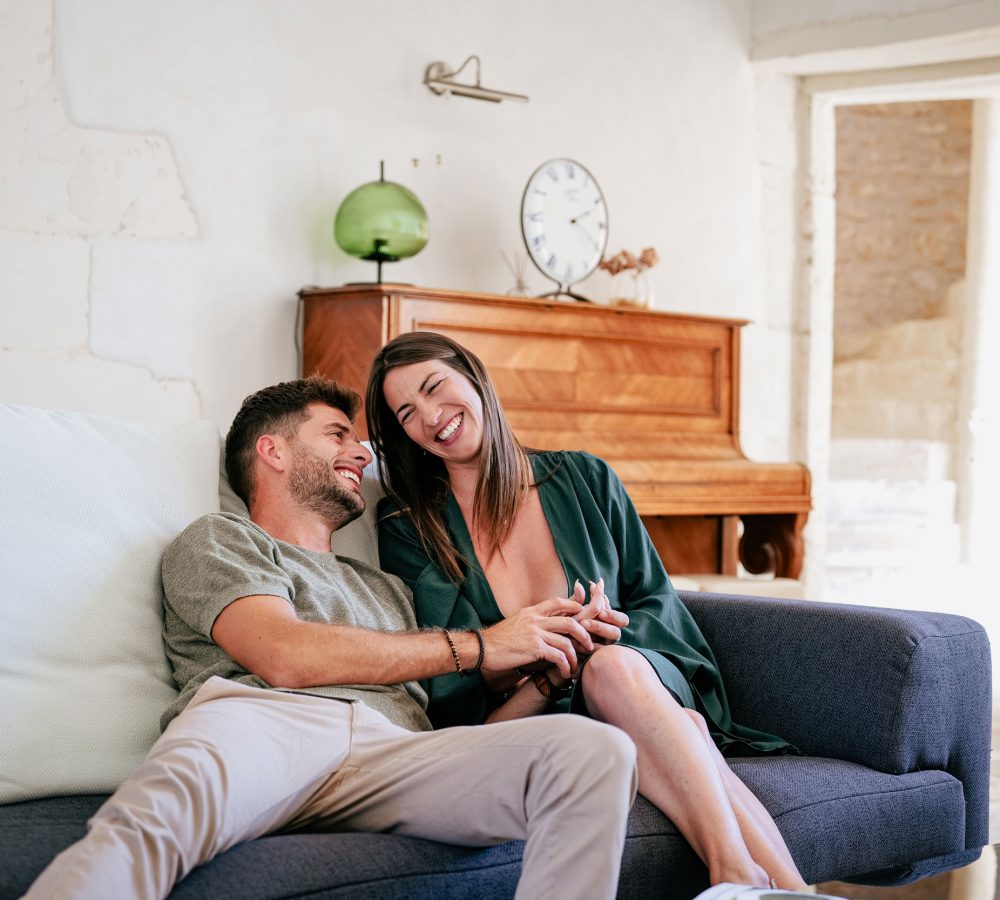 Couple dans un château en train de sourire sur le canapé